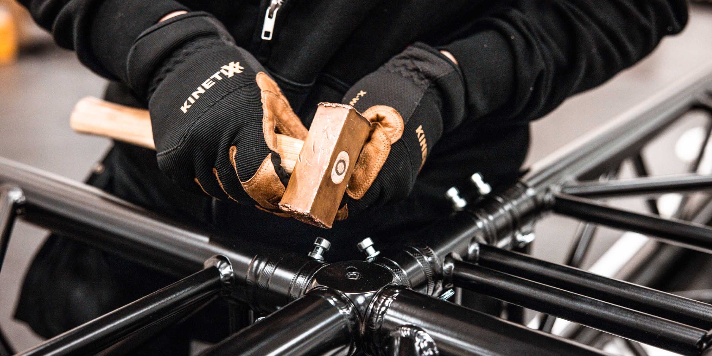 Techniker baut schwarzes Traversensystem für Messestand oder Eventtechnik auf