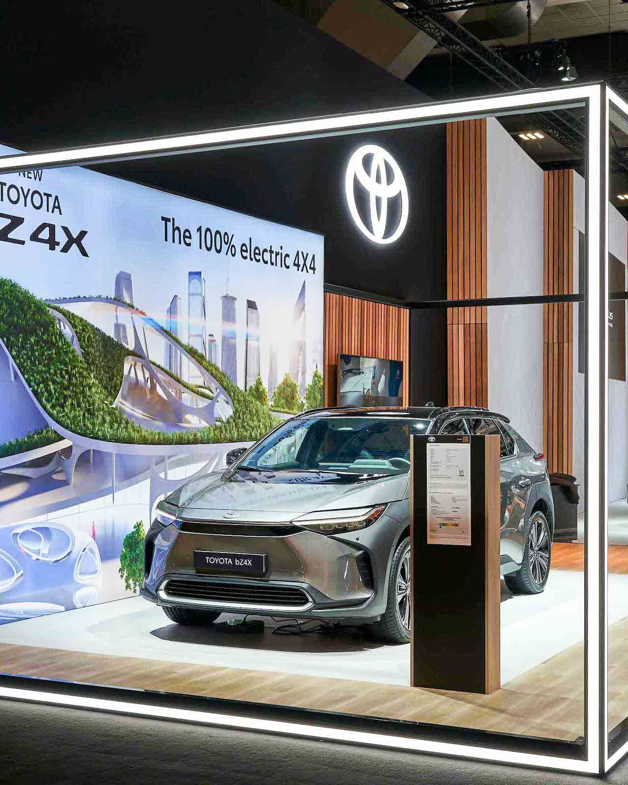 Toyota Messestand mit leuchtendem LED-Rahmen, Holzlamellenwänden und Toyota bZ4X