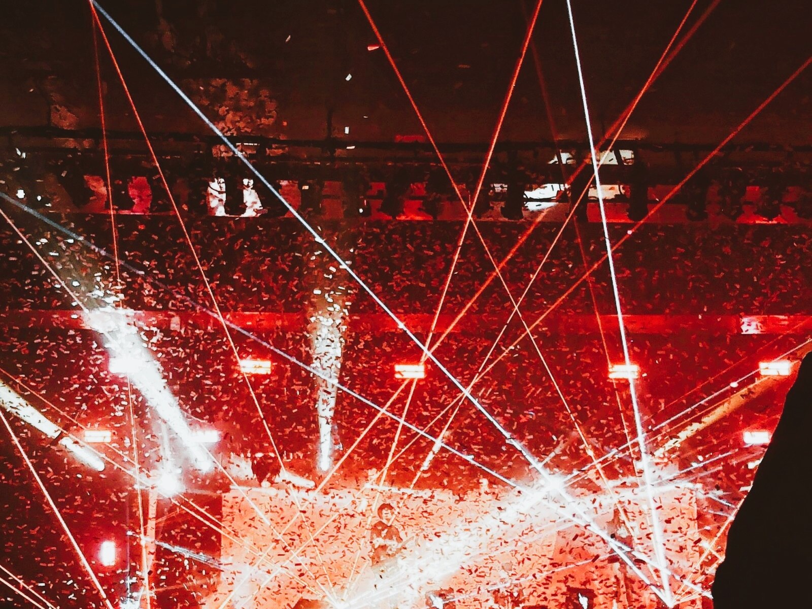 Laser Showbeleuchtung bei einem Konzert mit rotem Licht, Bühne und Publikum im Vordergrund