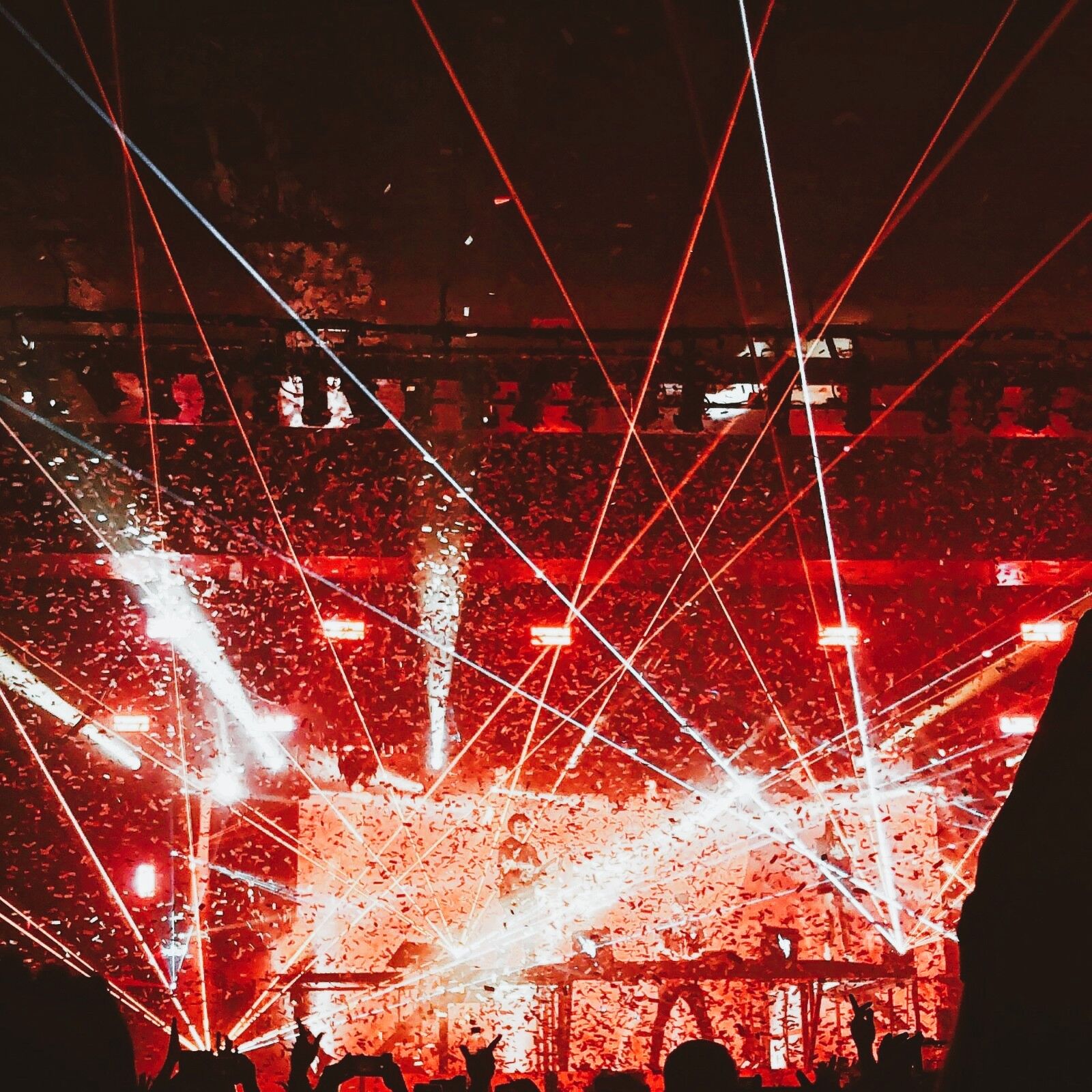 Laser Showbeleuchtung bei einem Konzert mit rotem Licht, Bühne und Publikum im Vordergrund