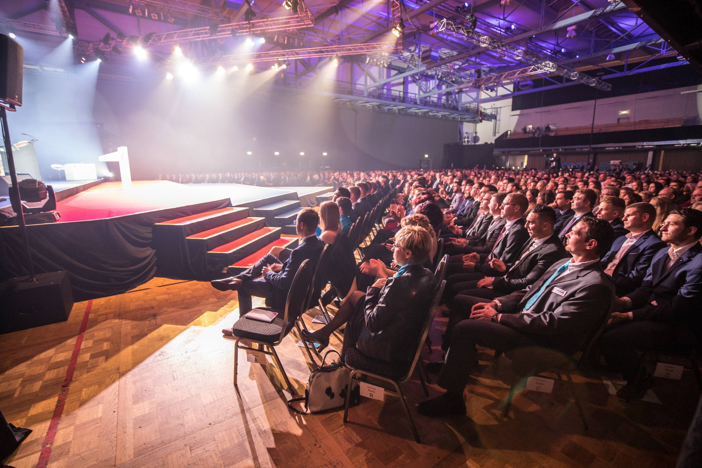 Firmenveranstaltung mit Bühne, Publikum und professioneller Veranstaltungstechnik