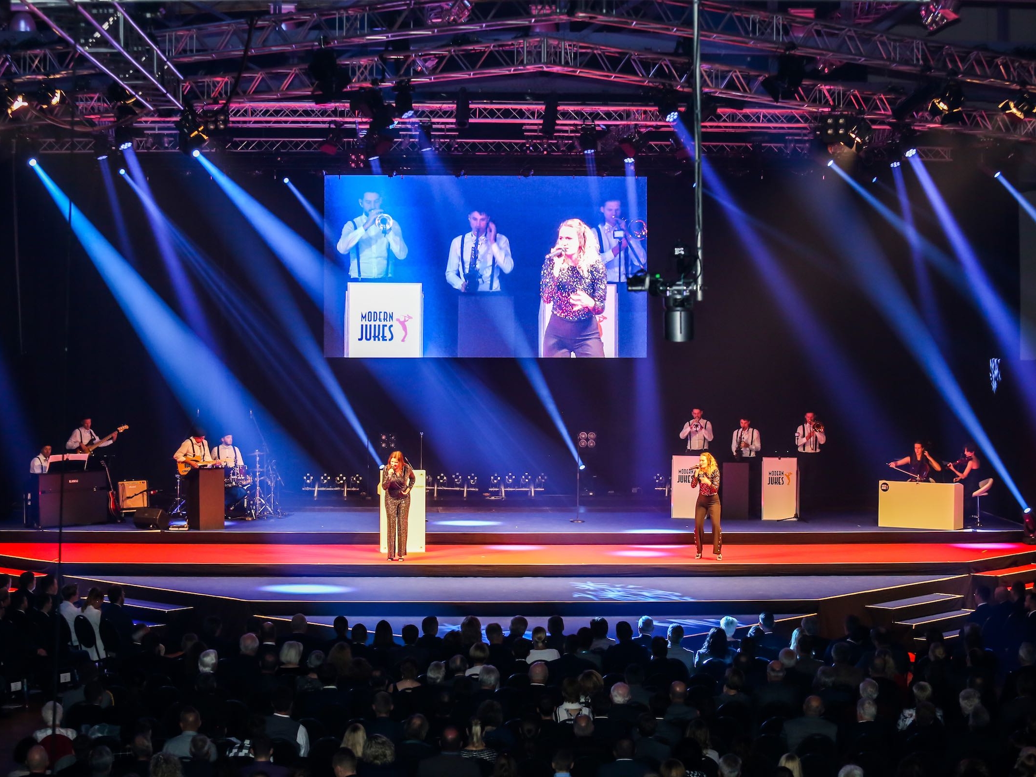 Liveband auf Bühne mit Lichttechnik und LED-Screen bei einer Veranstaltung