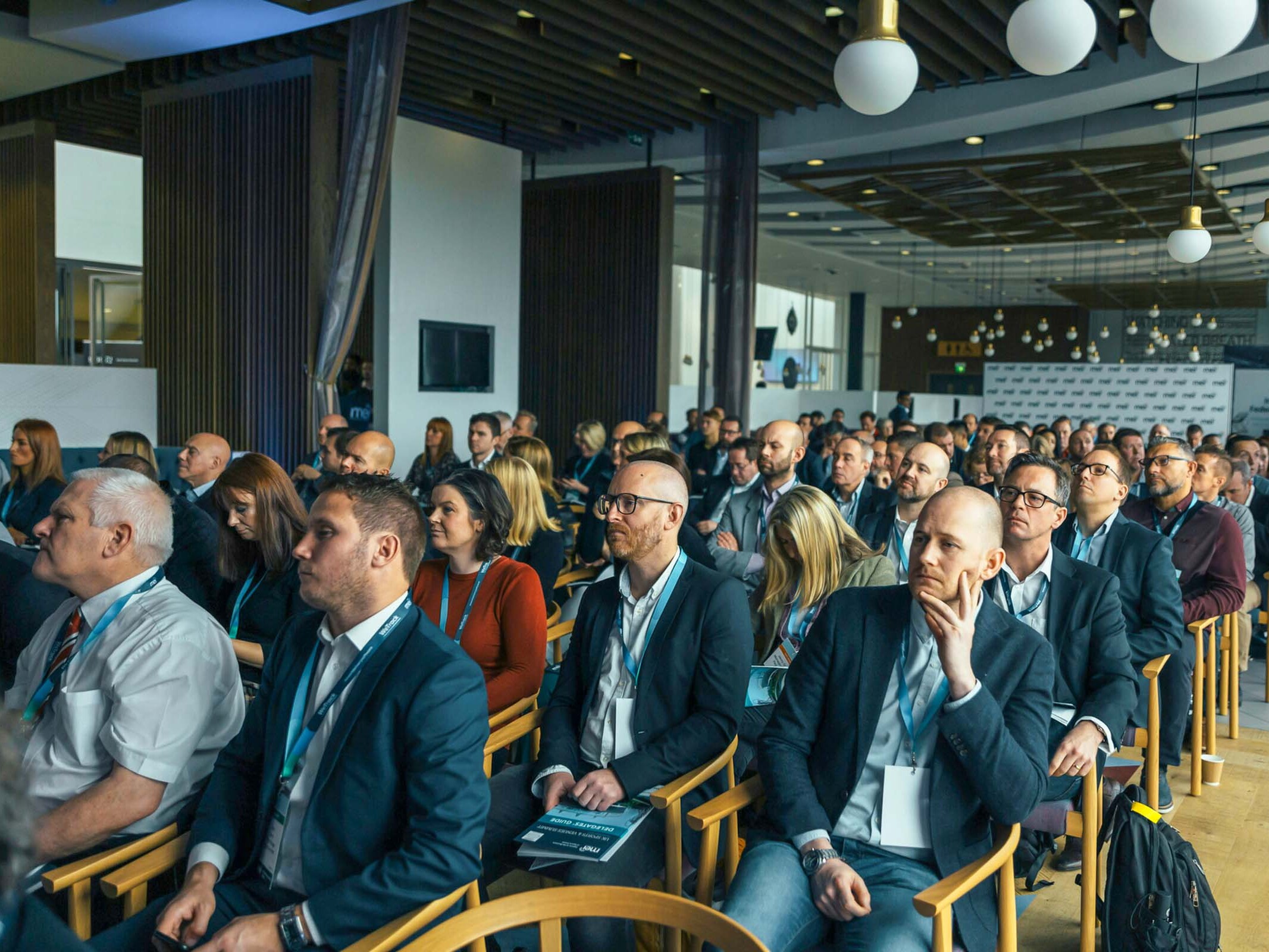Publikum bei Paneldiskussion mit Mikrofonen und Konferenztechnik