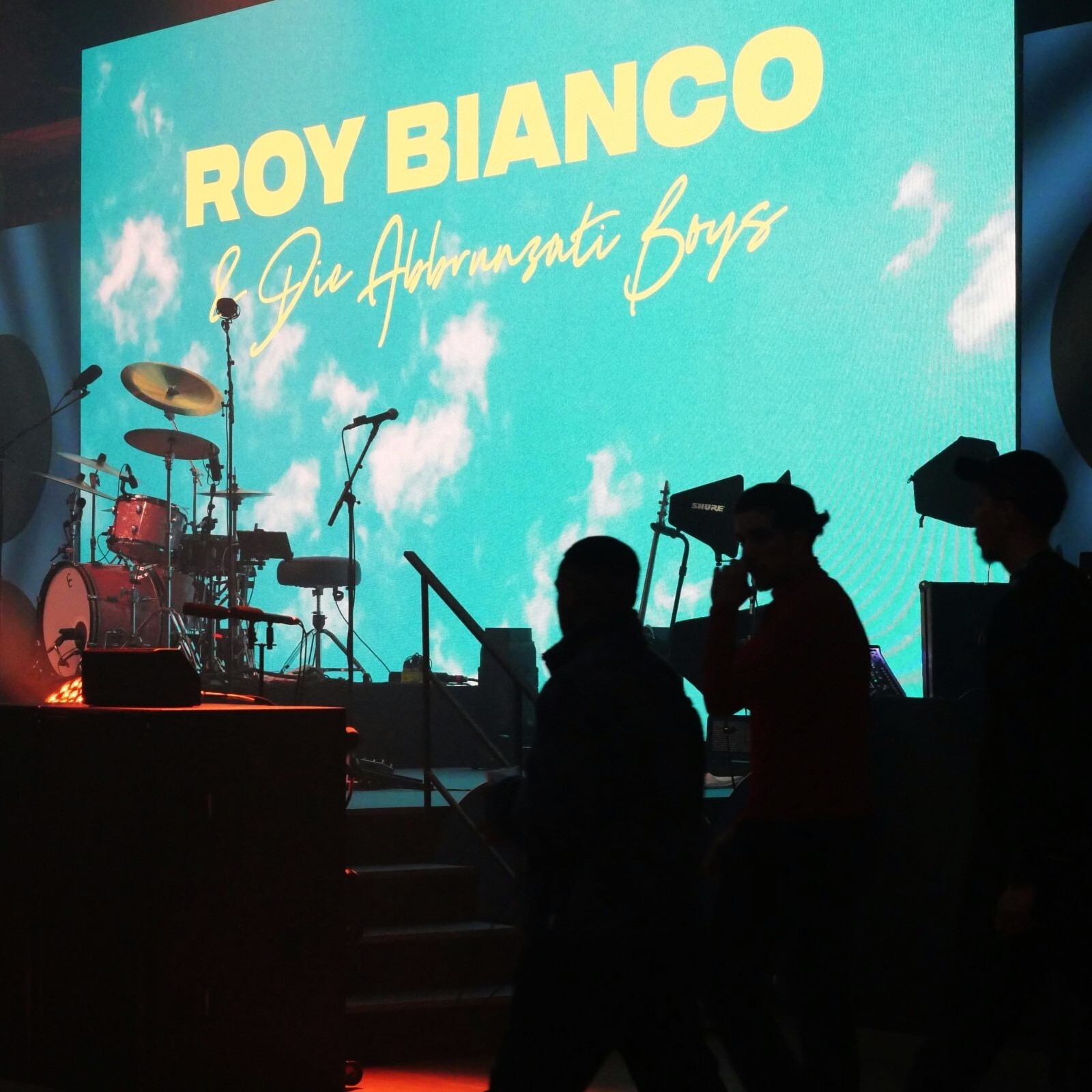 Konzertpublikum vor Bühne mit LED-Leinwand und Bühnenlicht bei Live-Musikveranstaltung