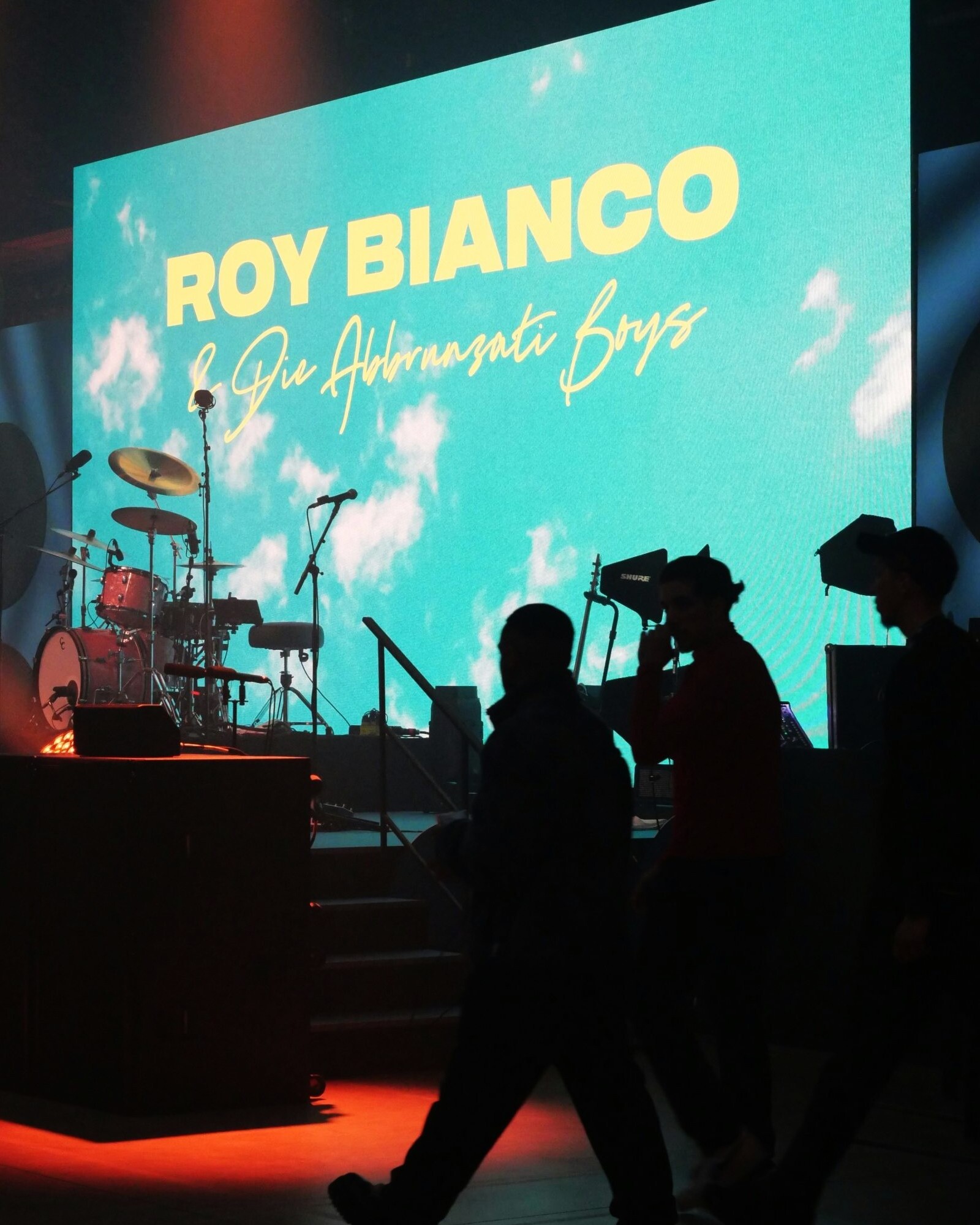 Konzertpublikum vor Bühne mit LED-Leinwand und Bühnenlicht bei Live-Musikveranstaltung